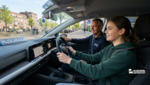 Driving School Amsterdam West met leerling en ervaren rijinstructeur tijdens een rijles